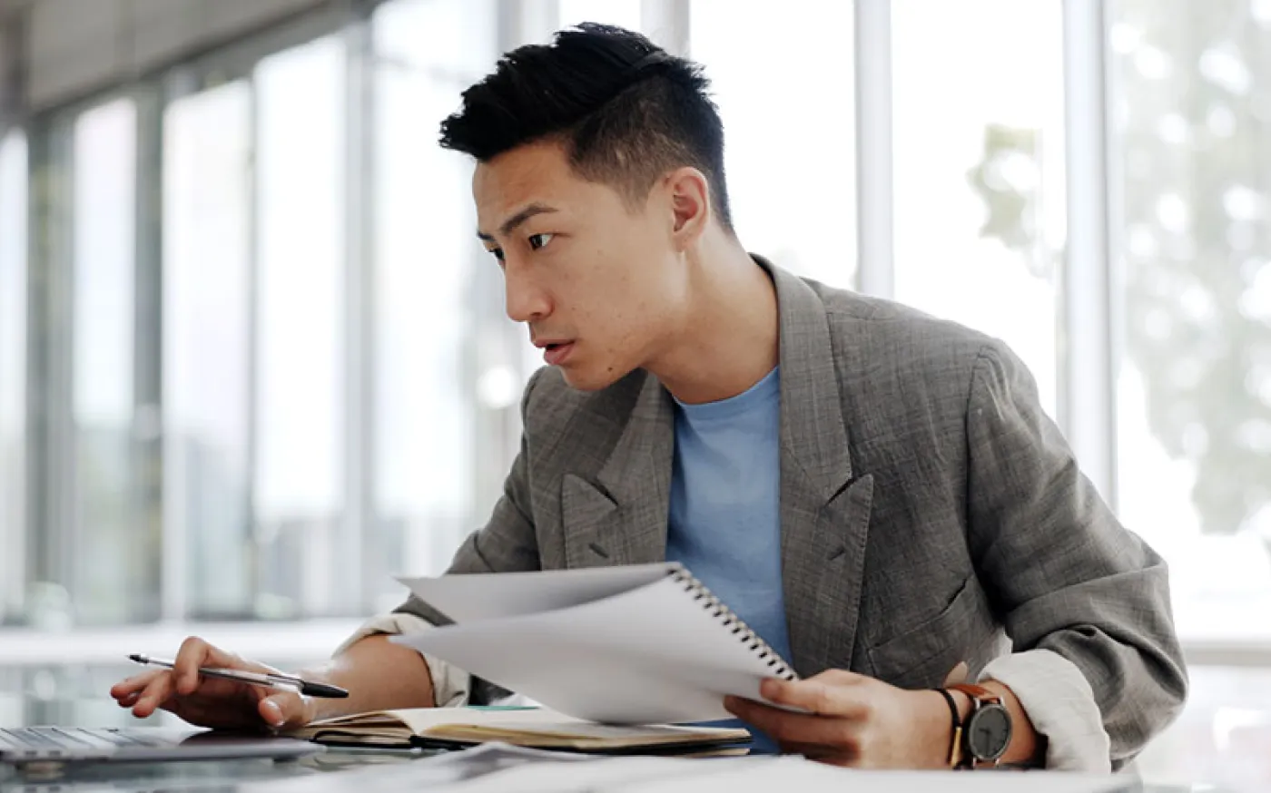 A business person in an open office working on a laptop.
